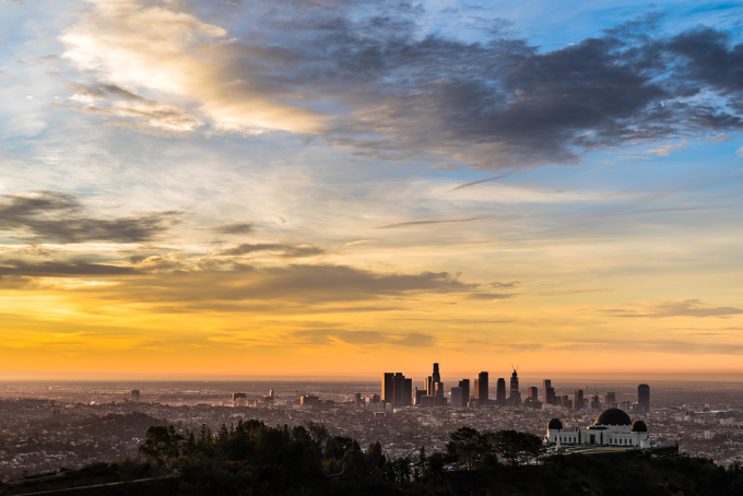 Aerial view of the downtown Los Angeles skyline and the Griffith Park Observatory just after sunrise during the golden hour