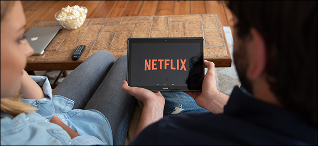 A couple watches Netflix together on a tablet.