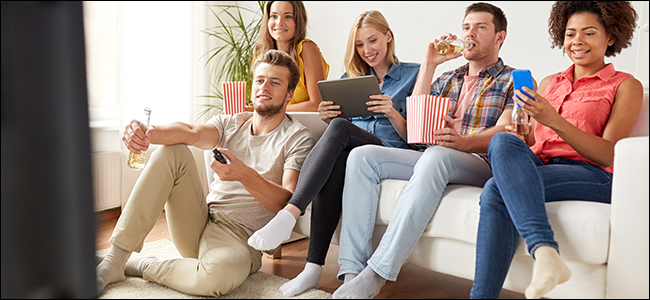 A group of friends watches Netflix on a couch.