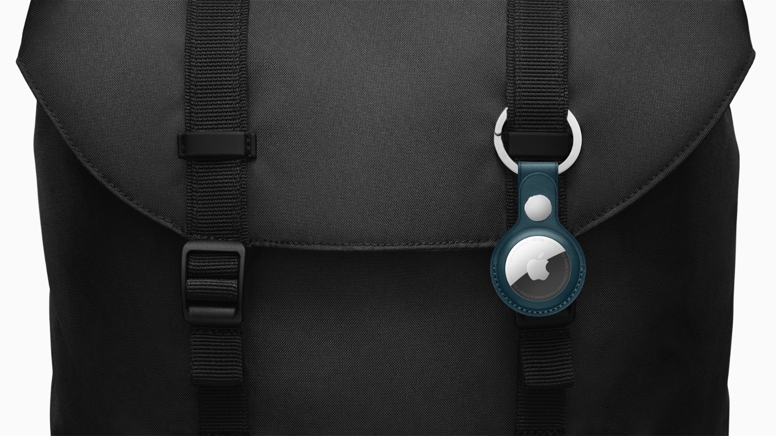 an airtag hooked on the front of a black backpack