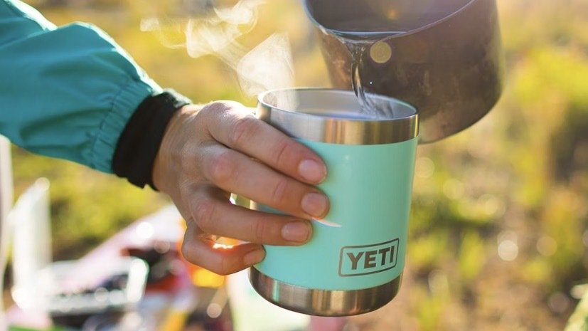 person pouring hot beverage into yeti lowball rambler outside
