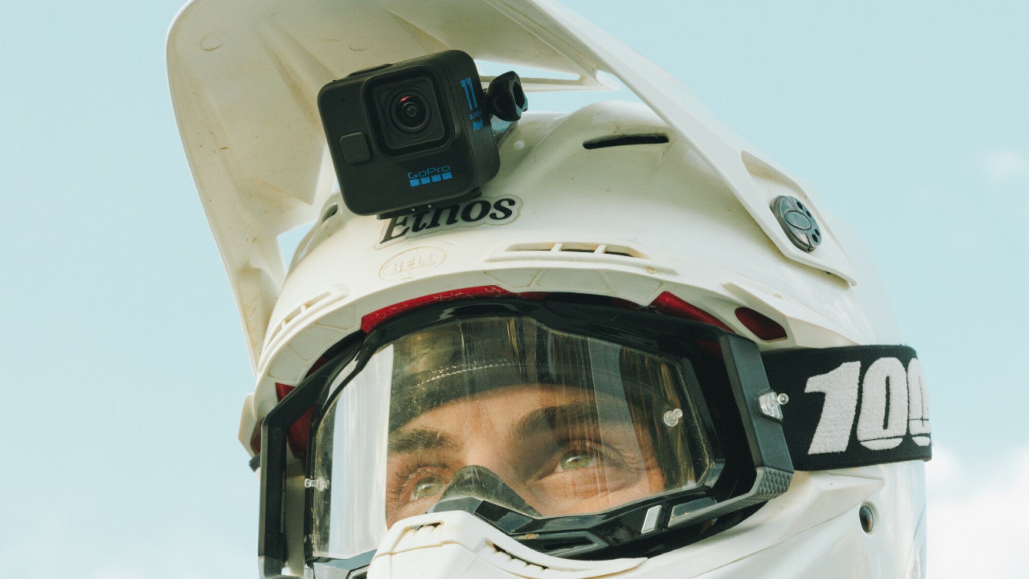 A photograph of a GoPro HERO11 Black Mini mounted on a motorcycling helmet.